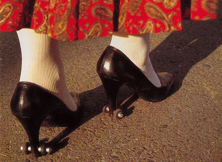 A photo of a pair of black high heeled shoes with little wheels attached suggesting that the wearer could roll along on the heels