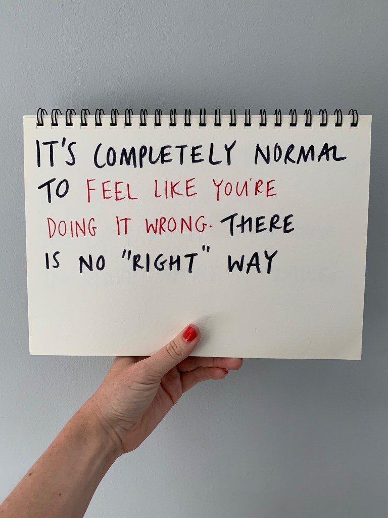 Hand, holding up a large note saying It's completely normal to feel like you're doing it wrong. There is no right way