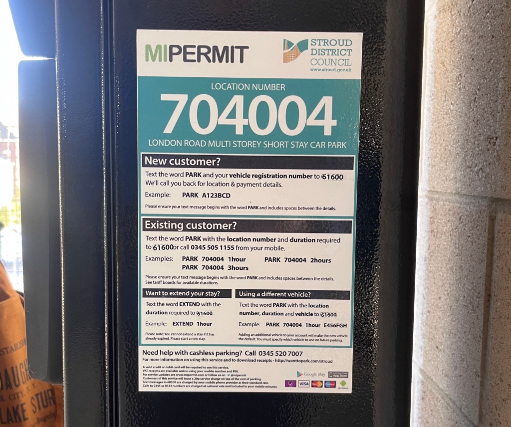 A photo of a large sticker with instructions about paying for parking via text message. 