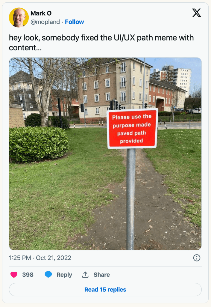 Tweet screen shot by Mark O @mopland. Text says "hey look, somebody fixed the UI/UX path meme with content". Image shows a well worn path through some grass in a built up area. A sign post says "Please use the purpose made paved path provided"