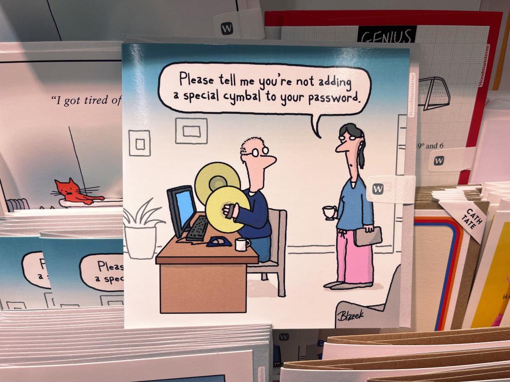 A basically drawn comic of a person sitting at a computer at a desk, holding two big brass hand cymbals. Another person says to them "is tell me you're not adding a special cymbal to your password". 