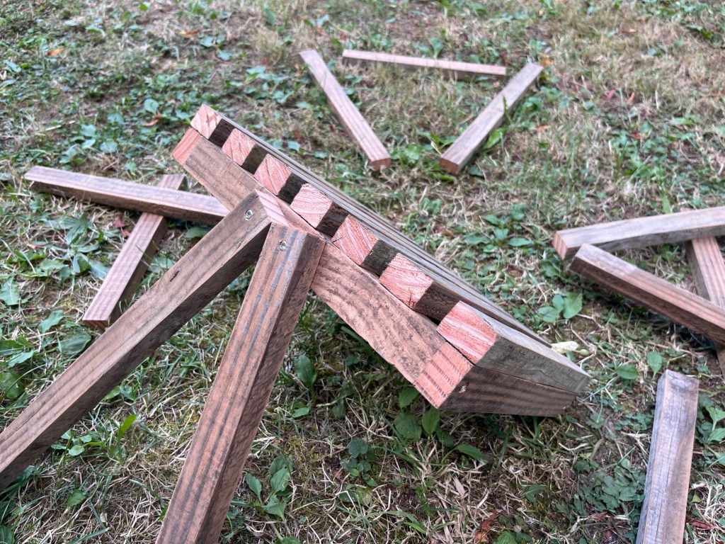 The first two pieces of wood are lined up and waiting to be screwed onto the seat. This photo is the last one on grass because I realised getting it level would be difficult to do on an uneven surface.