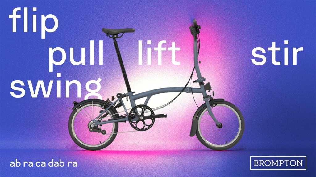 A grainy but bright purple and pink background with the words flip, pull, swing, lift, stir written across it, and an unfolded Brompton in the centre. The words ab ra ca dad ra are written in the bottom left corner. In the right corner, a Brompton logotype. 